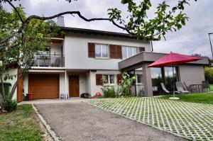 une maison avec un parapluie rouge devant elle dans l'établissement La Ruche, à Tramelan