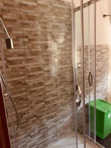 um chuveiro com uma porta de vidro e um balde verde em Appartamento Villa lucia em SantʼEufemia Lamezia