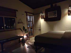 a bedroom with a bed and a window and a door at Jaadooghar Maatre Yoga Retreat in Marchula +40 photos