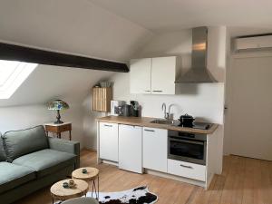 a living room with a couch and a kitchen at Authentic Stays - 4p-apartment in Eijsden