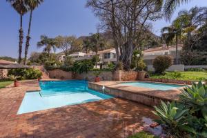 a swimming pool in a yard with palm trees at Waterfront Serenity View in Hartbeespoort