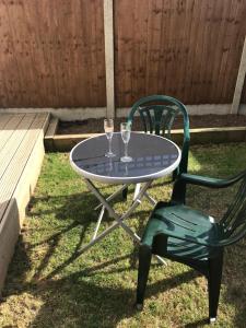 a table and a chair with two wine glasses on it at Richmond Luxury flat Fabulous location in Southend-on-Sea