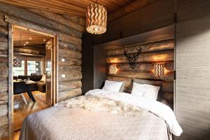 a bedroom with two beds and a wooden wall at UnelmaPirkelo in Ruka