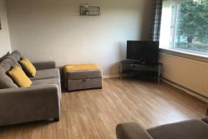 a living room with a couch and a flat screen tv at Newton Aycliffe Contractors Accommodation in Newton Aycliffe