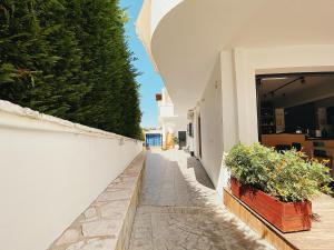 a walkway with potted plants on the side of a building at Villa White in Ksamil