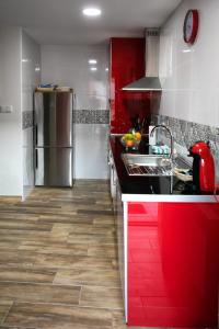 een keuken met rode kasten en een roestvrijstalen koelkast bij Casa Rural Ruplas in Villalba de Adaja