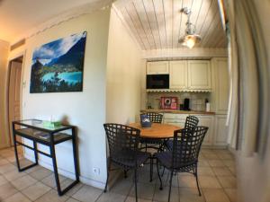 a kitchen and dining room with a table and chairs at L'Appart du Lac, Plage Privée in Duingt +16 photos