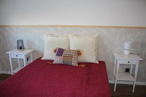 a bed with two tables and two pillows on it at Cabeço das Fráguas - apartamento centro cidade da Guarda in Guarda