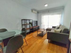 sala de estar con mesa de cristal y sofá en Apartamento con PARKING gratis en CENTRO, Merced, en Huelva