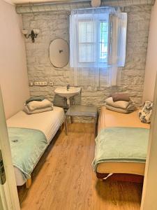 2 łóżka w pokoju z umywalką i oknem w obiekcie Süda Hostel w Tallinnie