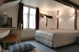 um quarto com uma cama, uma secretária e uma janela em Hôtel Les Trois Luppars em Arras