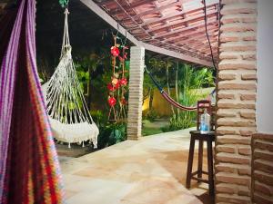 a patio with a hammock and a table with a lamp at Casa Jeri in Jericoacoara