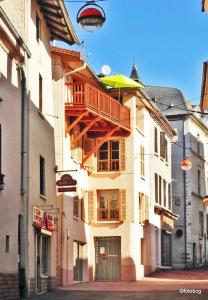 un edificio con balcón y sombrilla en Chambre d'hôtes Les Myriades D'Or, en Regny