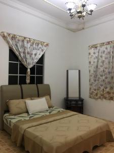 a bedroom with a bed and a window with curtains at Seribu 1 Homestay 3 Rooms in Kundasang