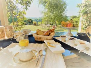 una mesa con alimentos para el desayuno y un bol de fruta en Chambre avec sa salle de bain privée attenante et wc privé en Larroque-sur-lʼOsse