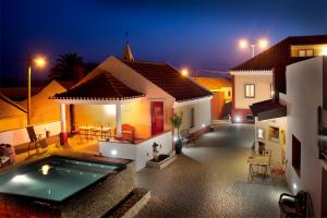a house with a swimming pool in the yard at night at Artvilla in Cadaval