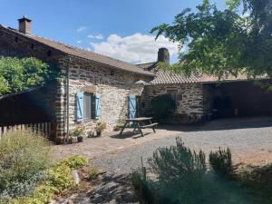 a stone house with a picnic bench in front of it at Domaine du Plan del Poux Gîte rural in Combret