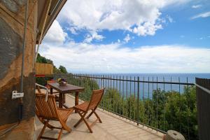 balcón con mesa, sillas y vistas al océano en La Musa, en Bergeggi
