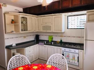 a kitchen with white cabinets and a table and chairs at La Gaviota B1 in Juan Dolio
