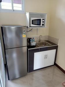 a kitchen with a stainless steel refrigerator and a sink at 1โฮมสเตย์ in Nakhon Si Thammarat