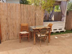 a table and two chairs and a table and a fence at Zimmer Belev HaKikar- Dead sea in Neʼot HaKikar