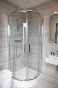 een badkamer met een douche, een toilet en een wastafel bij Paddington Park Hotel in Londen