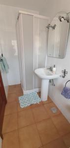 a white bathroom with a sink and a mirror at La Hoyilla Hostel - La Aldea in San Nicolás