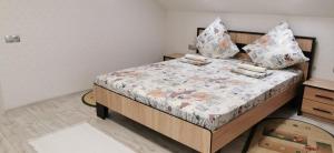 a bedroom with a bed with pillows on it at Apartman in Velyka Bihan Берегівський район - Закарпаття in Velyka Bihanʼ