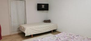 a room with two beds and a tv on the wall at Apartman in Velyka Bihan Берегівський район - Закарпаття in Velyka Bihanʼ