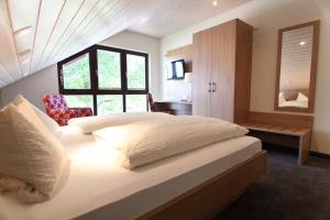 Schlafzimmer mit einem großen weißen Bett und einem Fenster in der Unterkunft Pension zur Weinlaube in Bornheim