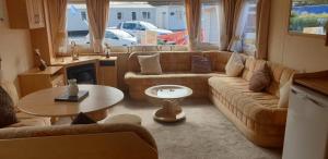 a living room with a couch and a table at Park Home at Golden Sands Holiday Park N.Wales in Rhyl