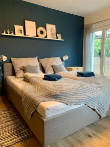 a bedroom with two beds and a blue wall at Laura‘s Heimat in Bad Bergzabern