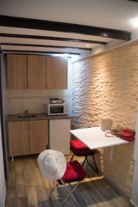 une cuisine avec une table blanche et des chaises rouges dans l'établissement Double Decker Apartment, à Belgrade