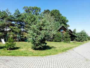 a tree in a field next to a house at Sosnowa Oaza in Baranów Sandomierski