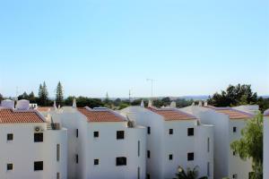 a row of white houses with red roofs at Sunny Vilamoura Pool Apartment- Free Parking- Fiber Wi-Fi in Vilamoura