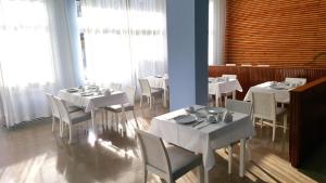 a dining room with white tables and white chairs at Mary Hotel in Limenas