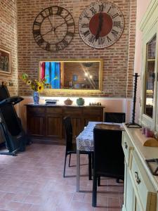 uma sala de jantar com uma mesa e um relógio na parede em Luxury Apartments Casa Burraia em Abbadia di Montepulciano