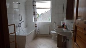 a bathroom with a tub and a toilet and a sink at Ferienwohnung Ostseebad Karlshagen in Karlshagen +12 photos