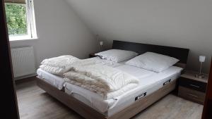 Una cama con mantas blancas y almohadas en un dormitorio en Ferienwohnung Ostseebad Karlshagen, en Ostseebad Karlshagen