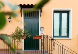 una puerta verde en una casa naranja con una planta en Casale Catania, en Catania