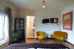 グルペンにあるDe Auw Sjoekelaatfabriekの椅子2脚とテーブルのあるリビングルーム