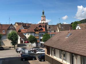 uma cidade com carros estacionados num parque de estacionamento com uma torre de relógio em Fewo Belinda, Tiengen Zentrum em Waldshut-Tiengen