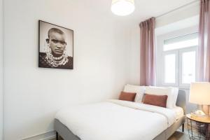 Un dormitorio con una cama blanca y una foto en la pared en The Lisbon Lotus - Alcantara, en Lisboa