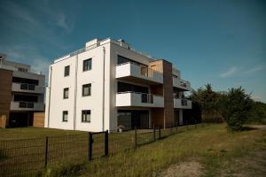 a white building with a fence in front of it at Moderne Ferienwohnung mit Seeblick & Terrasse 96qm in Großräschen