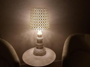 a lamp sitting on a table next to two chairs at Aqua Boutique Hotel in Castiglione della Pescaia