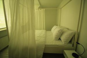 Piccola camera con letto e cuscini bianchi. di House Akerdijk 5 persons 3 bedrooms a Badhoevedorp