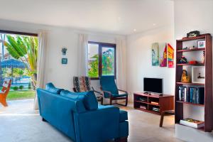 salon z niebieską kanapą i telewizorem w obiekcie Apartamento no Taiba Beach Resort w mieście Taíba