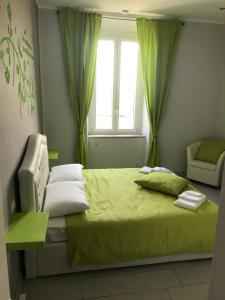 Un dormitorio con una cama con sábanas verdes y una ventana en Rosa verde en Caselle Torinese