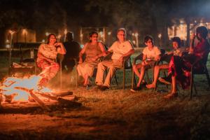 a group of people sitting around a fire at Tranquil Wild in Tanamalwila