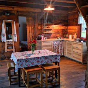 a kitchen with a table and some wooden walls at Naša mala koliba in Vojnić